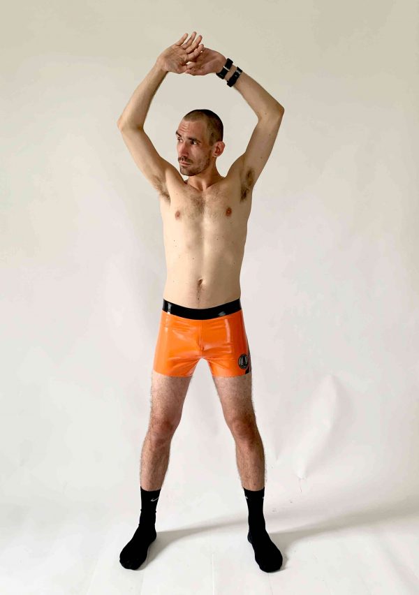 Latex, Rubber Hotpants. Eng anliegend in Orange mit schwarzen Streifen und schwarzem Bund. Eng anliegend für Herren, Kerle und Jungs