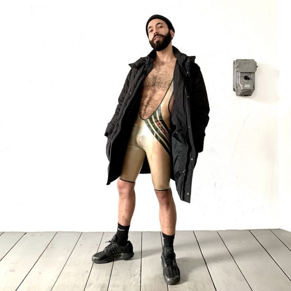 Rubber Latex Wrestler Body in transparent, mit oliv Streifen und oranger Logoschrift, sportlich slim fit geschnitten für Männer, Kerle & Jungs