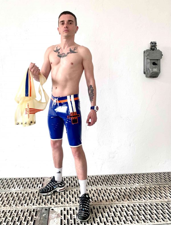 Rubber Latex Fetisch kurze Biker  Sport Hose in blau mit Kordel Zug weißen Seitenstreifen und Logo. Für Jungs, Kerle und Männer, gay, queer