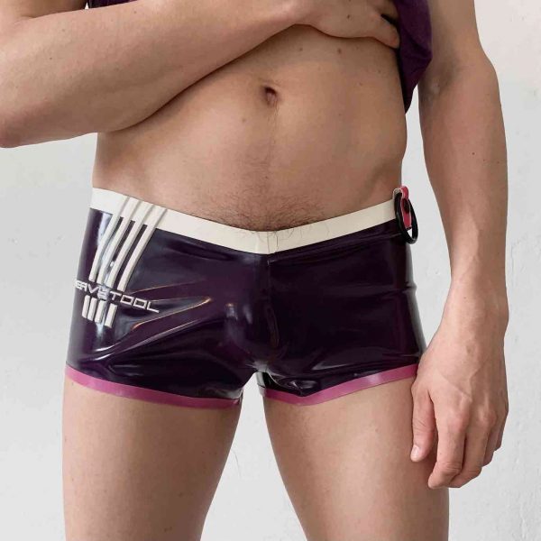 Latex Rubber Hotpants, Badehose in violett mit Heavytool Logo in Weiß und Rosa Bündchen + Cockring Halter. Für Queer Gay Boys, Kerle, Jungs, Männer.