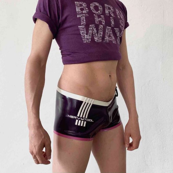 Latex Rubber Hotpants, Badehose in violett mit Heavytool Logo in Weiß und Rosa Bündchen + Cockring Halter. Für Queer Gay Boys, Kerle, Jungs, Männer.