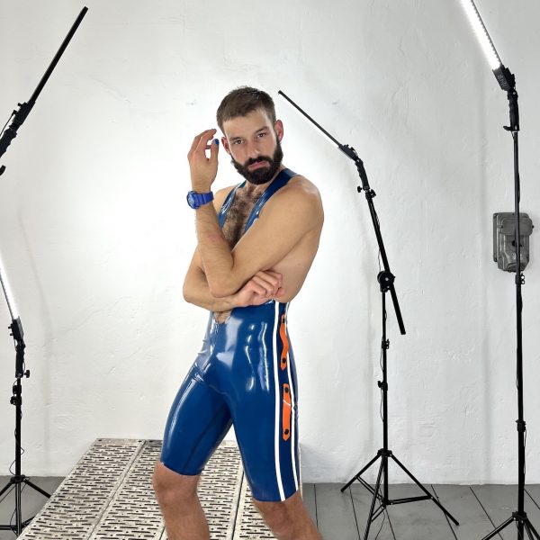 Latex / Rubber Fetisch Wrestlerbody, in transparent blau mit weißen Seitenstrifen, Logo und orangen Design Elementen. Für Männer, Kerle Boys und Queers